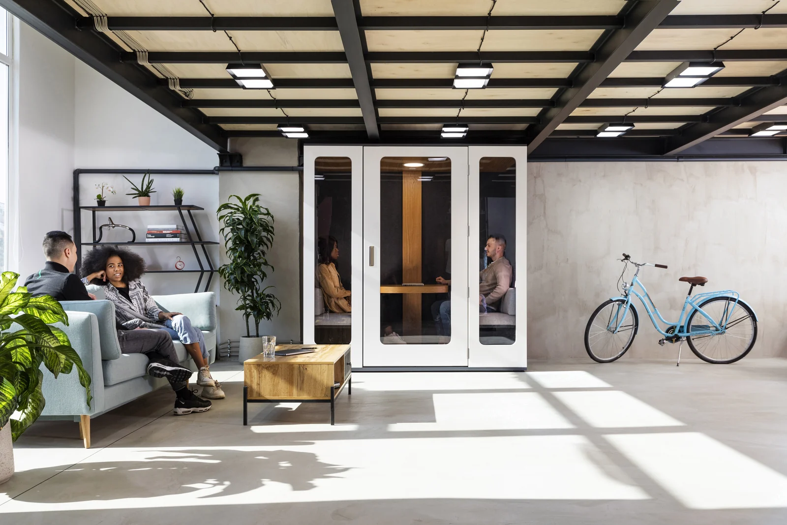Two people meeting in a white MEAVO Camden pod beside an office lounge