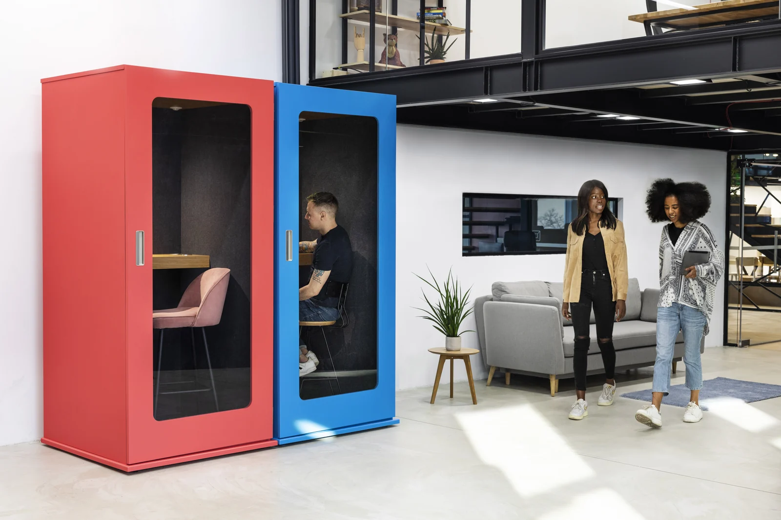 Coral and blue MEAVO Soho phone booths in an open-plan office